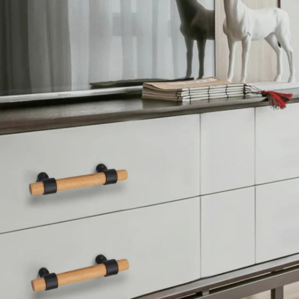Wood drawer handles with gold mounts on modern white cabinet doors.