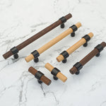 Multiple walnut drawer handles in dark wood with black mounts.