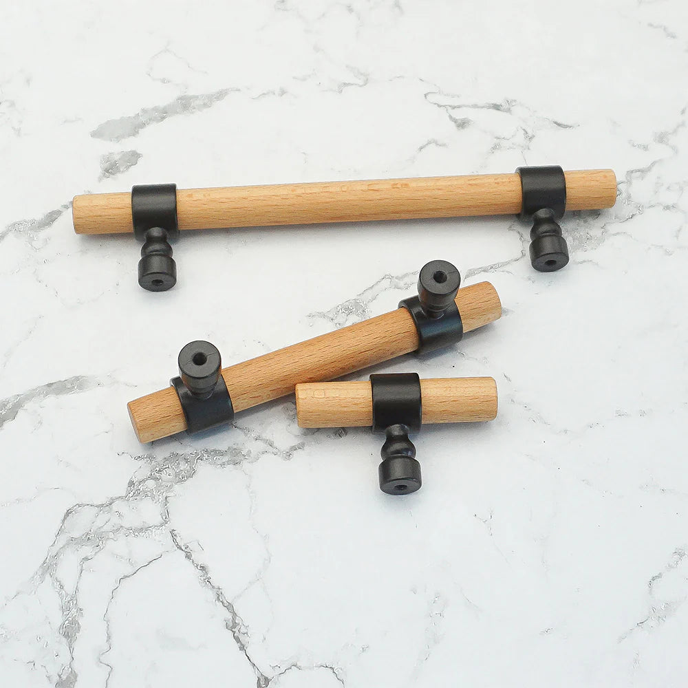 Wood drawer handles with black brackets displayed on marble.