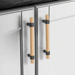 Wood drawer handles installed on white cabinet doors.