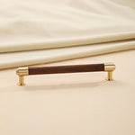 Single walnut brass cabinet handle, sleek decorative style.