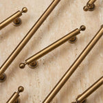 Collection of gold cabinet handles on a beige marble background
