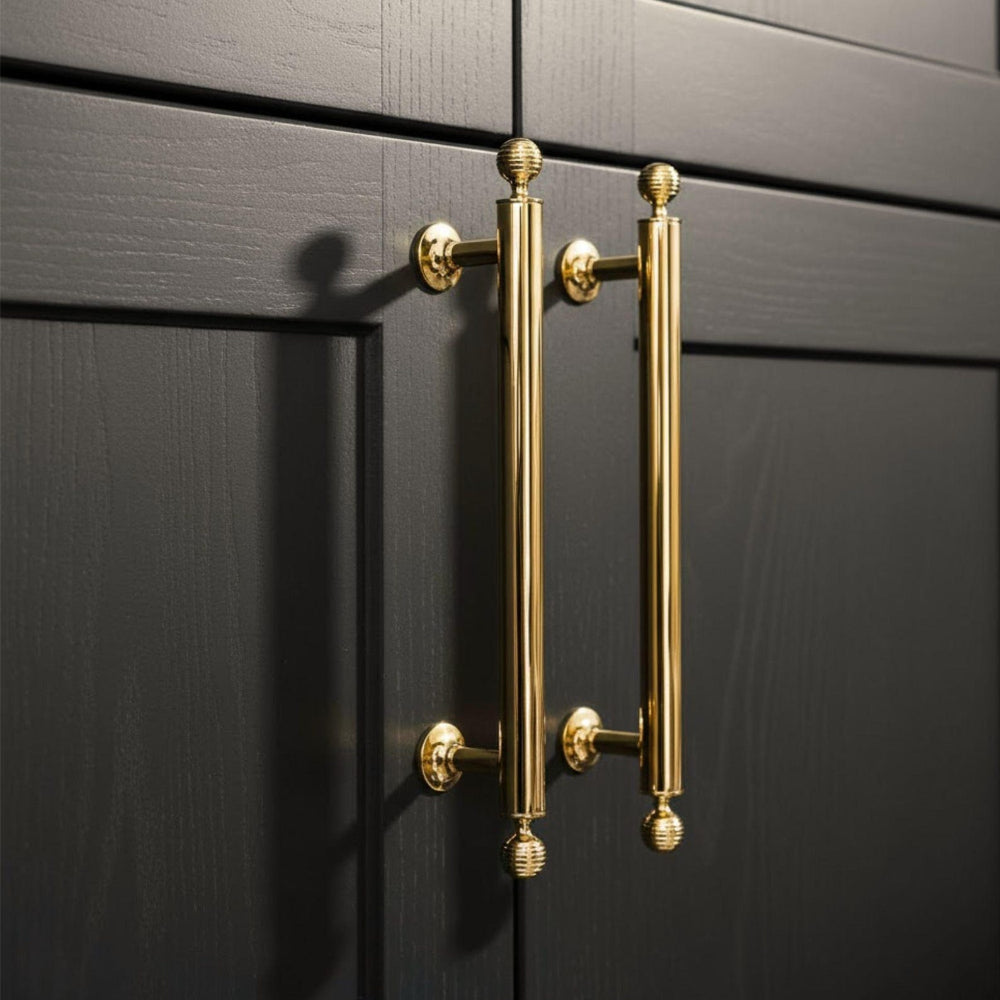 Gold cabinet handles on a black cabinet