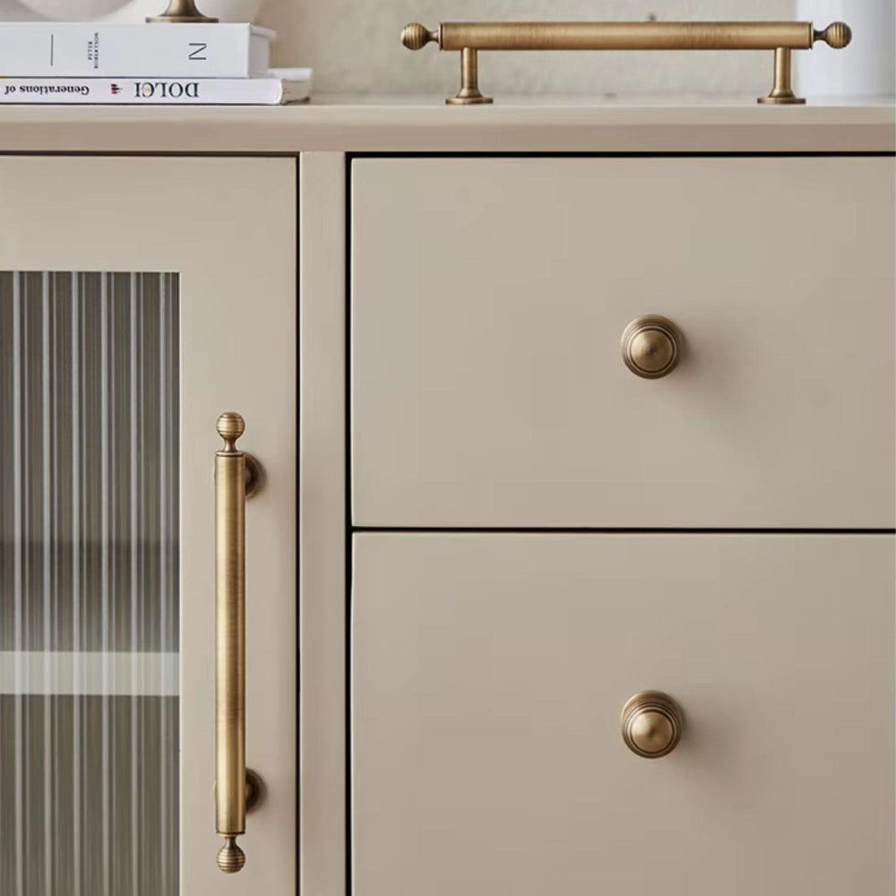 Beige cabinet with brass handles and knobs