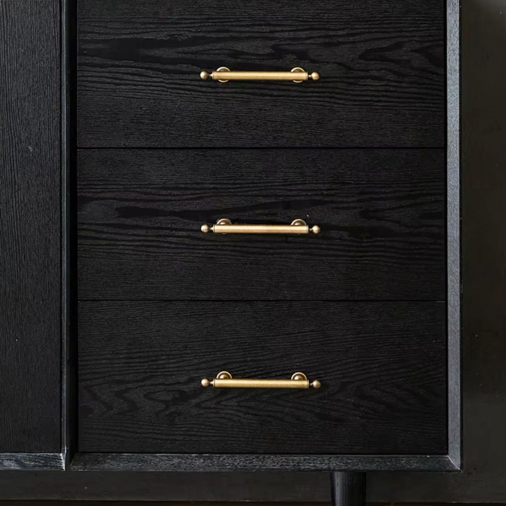 Black dresser with gold handles on a dark background