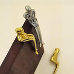 Decorative wall hooks with gold and silver designs on a beige background