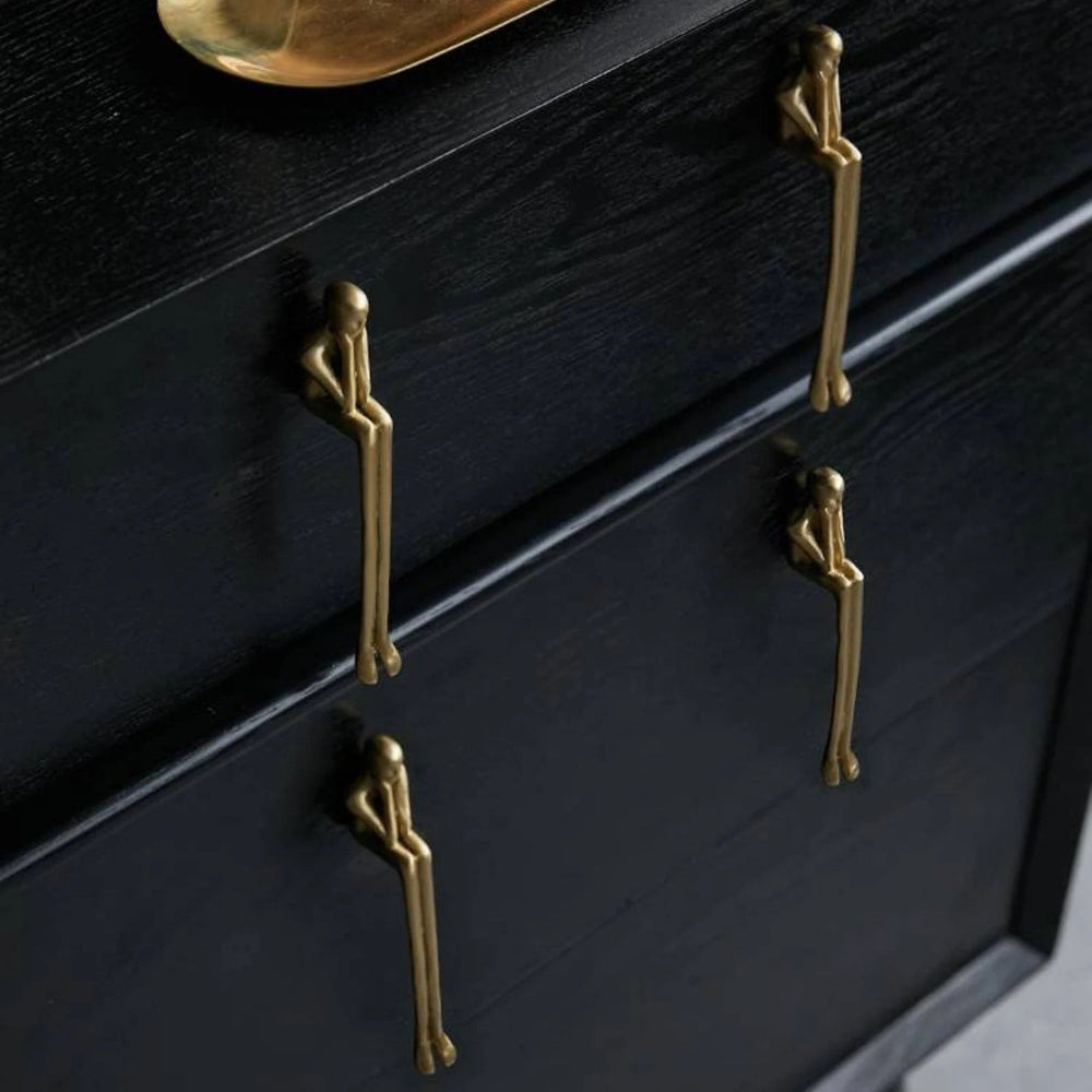 Black dresser with gold sitting person handles