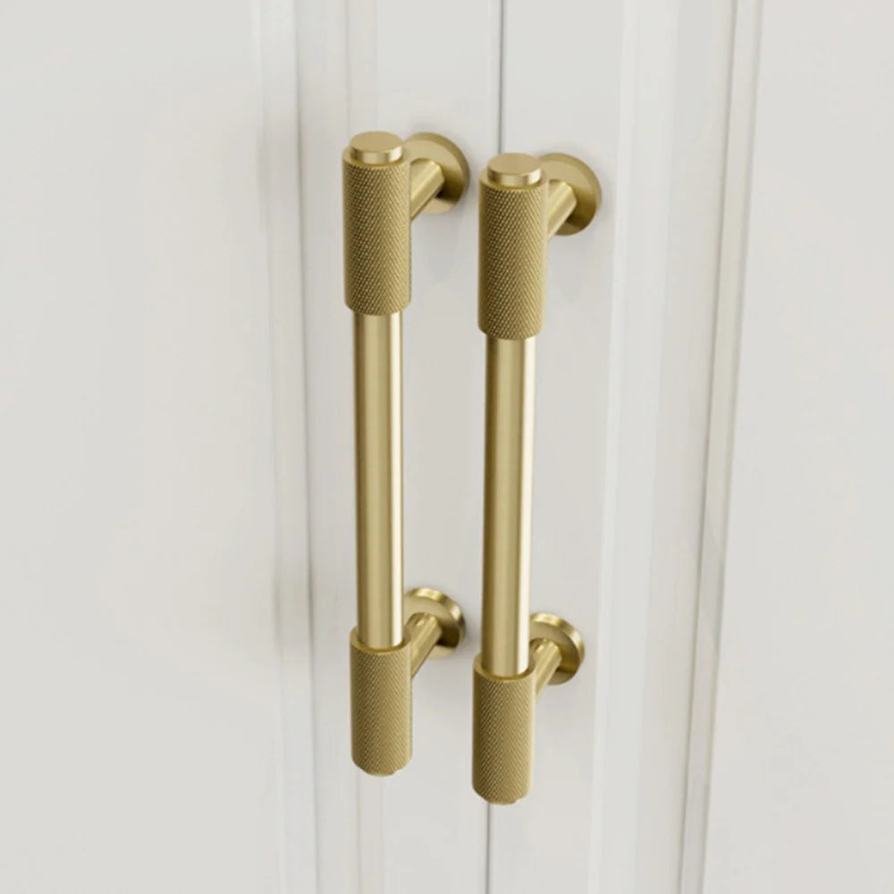 Textured brass cabinet pull handle with vintage finish on the white door
