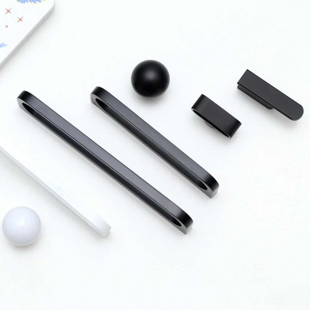 Black and white cylindrical objects on a white surface with a patterned paper in the background