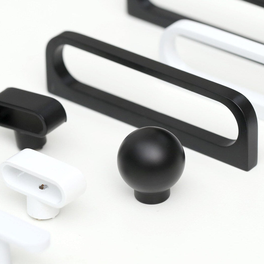 Collection of black and white cabinet handles on a white background
