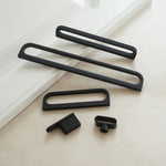 Set of black metal brackets on a light wooden surface