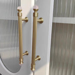 Gold handles with pink knobs on a glass door