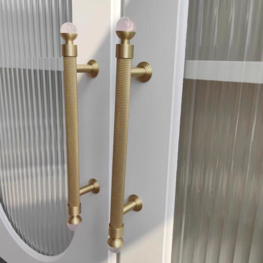 Gold handles with pink knobs on a glass door