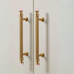 Gold door handles with pink knobs on a white background