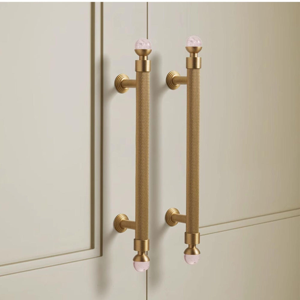 Gold cabinet handles on a light-colored cabinet door